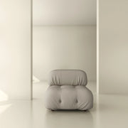 Modern tufted armchair in neutral minimalist interior with soft, light beige tones